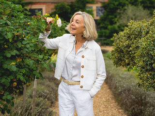 Liz Astor in the garden, drawing down a rose